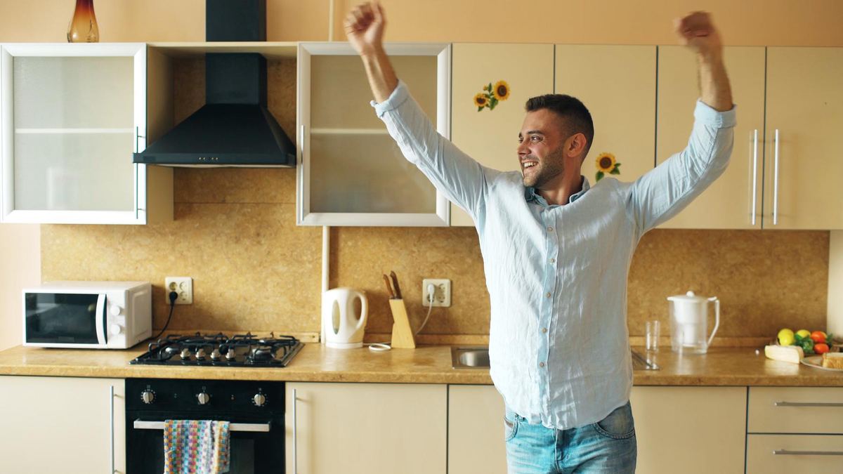 A man dancing happily in his kitchen